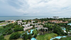 Vista aérea de un complejo turístico con varias edificaciones, un amplio área de piscina y vistas al océano.