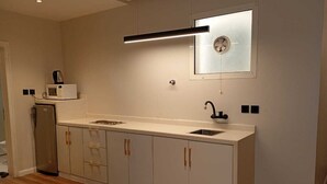 A modern kitchen with a built-in microwave, a sink, and a window above the countertop. - ALWURUD ALARBA FOR SERVICED APARTMENTS (Riyadh)