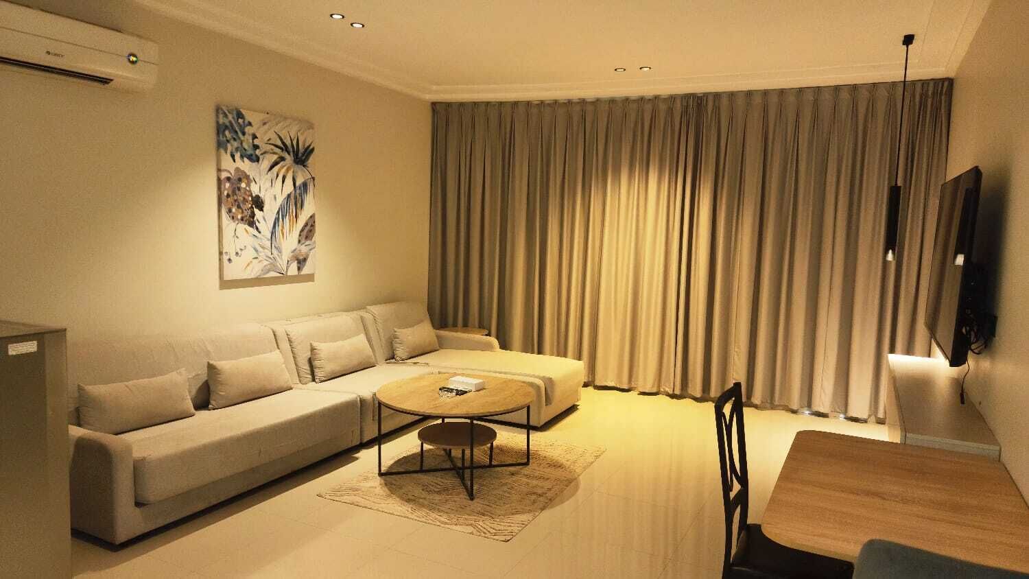 A modern living room with a sofa, coffee table, and dining table.