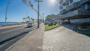 A street with a building labeled 'Dior Salon Apart Service' and a clear sky. - Apartment With Balcony and sea View - Ier0305 (Salvador)