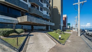 A hotel entrance with a paved driveway, a small lawn, and a building with a sign for 'Dior Salon Apart Service.' - Apartment With Balcony and sea View - Ier0305 (Salvador)