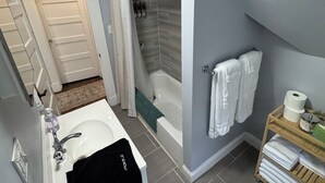 A modern bathroom with a bathtub, shower, and toilet. - Spacious Yale 2BR with Full Kitchen & WiFi (New Haven)