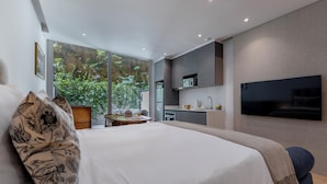 Une chambre d’hôtel moderne dotée d’un grand lit, d’un coin repas et d’une cuisine.