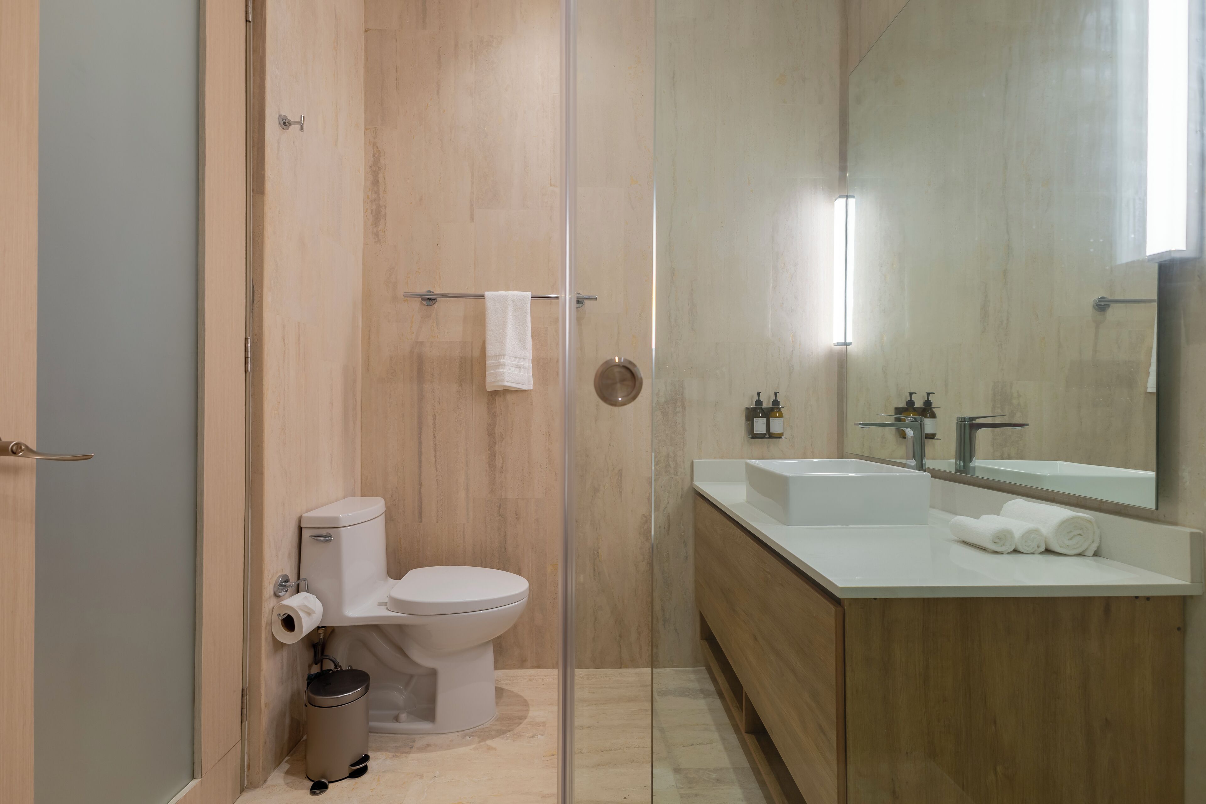 Une salle de bain moderne avec des toilettes, un lavabo et un miroir.