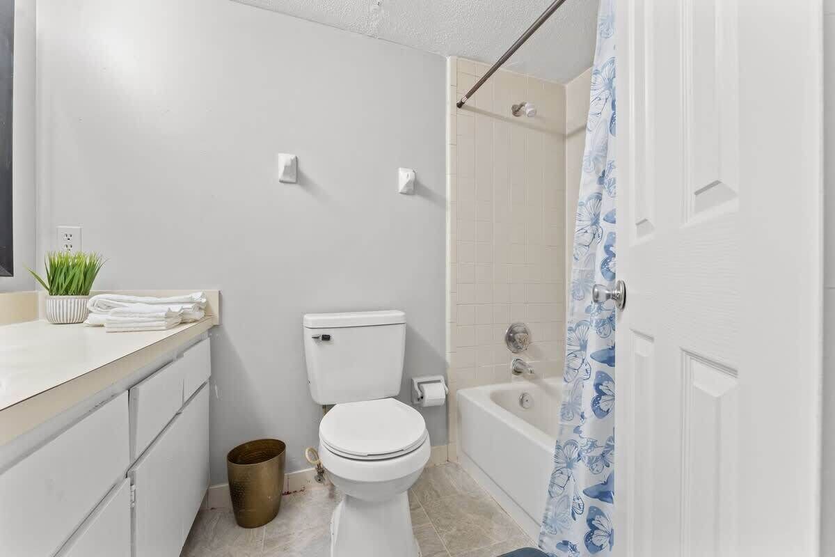 Une salle de bain avec des toilettes, un lavabo et une baignoire.