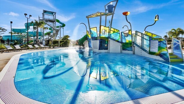 A swimming pool with a water slide and a multi-level water feature.