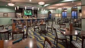A hotel dining area with multiple tables and chairs, a bar, and large windows with a view. - 6BR Villa w/ Private Pool – Champions Gate (Four Corners)