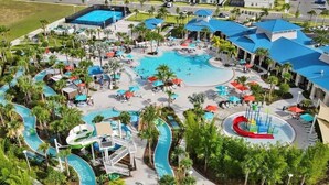 An aerial view of a resort with multiple swimming pools, water slides, and lounge areas surrounded by palm trees. - 5BR Windsor Island Home, Private Pool (Kissimmee)