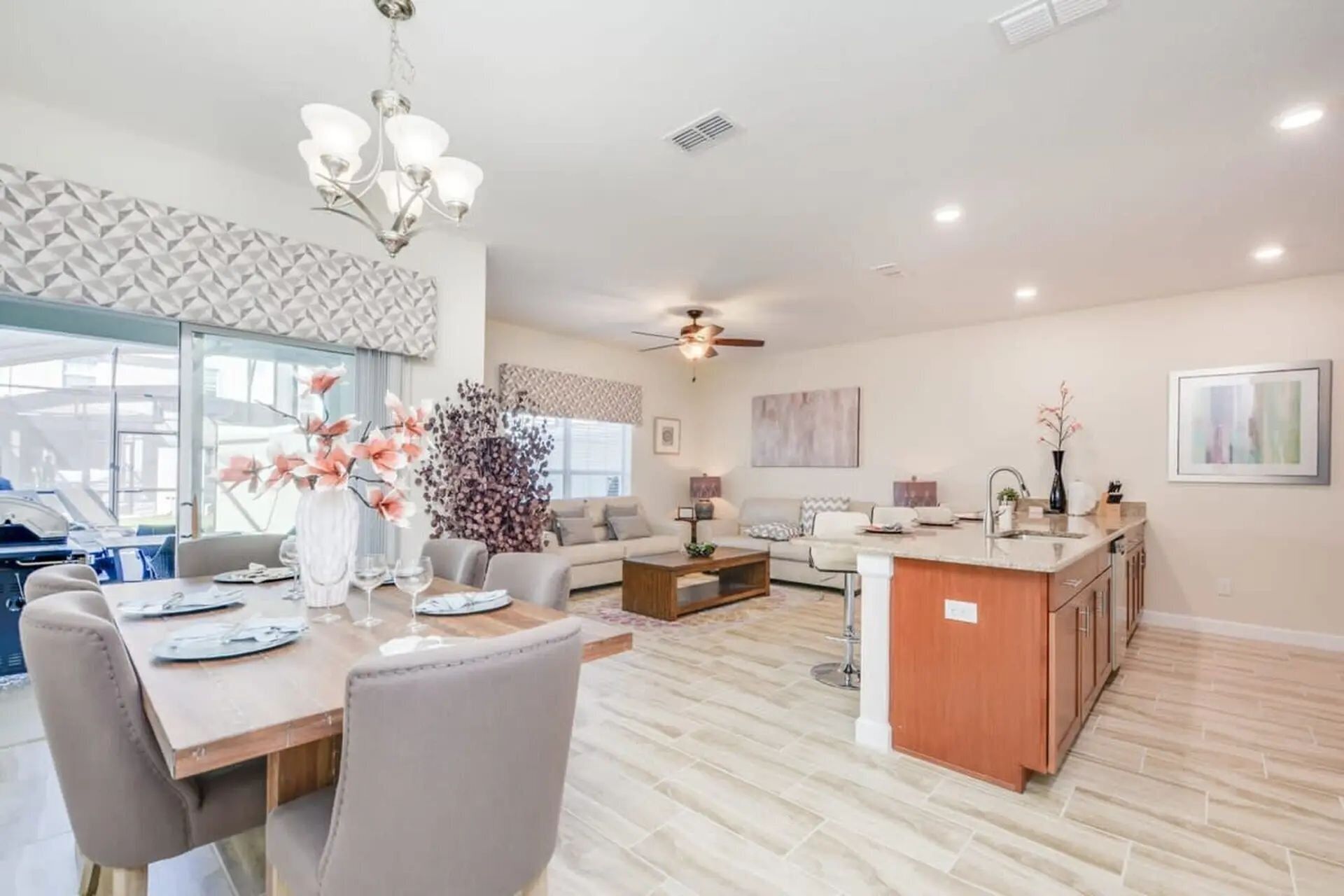 A spacious living area with a dining table, sofas, and a kitchen island.
