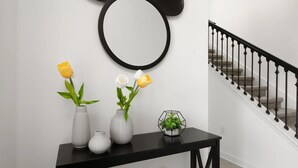 Una escalera con barandilla negra y un espejo redondo fijado a la pared.