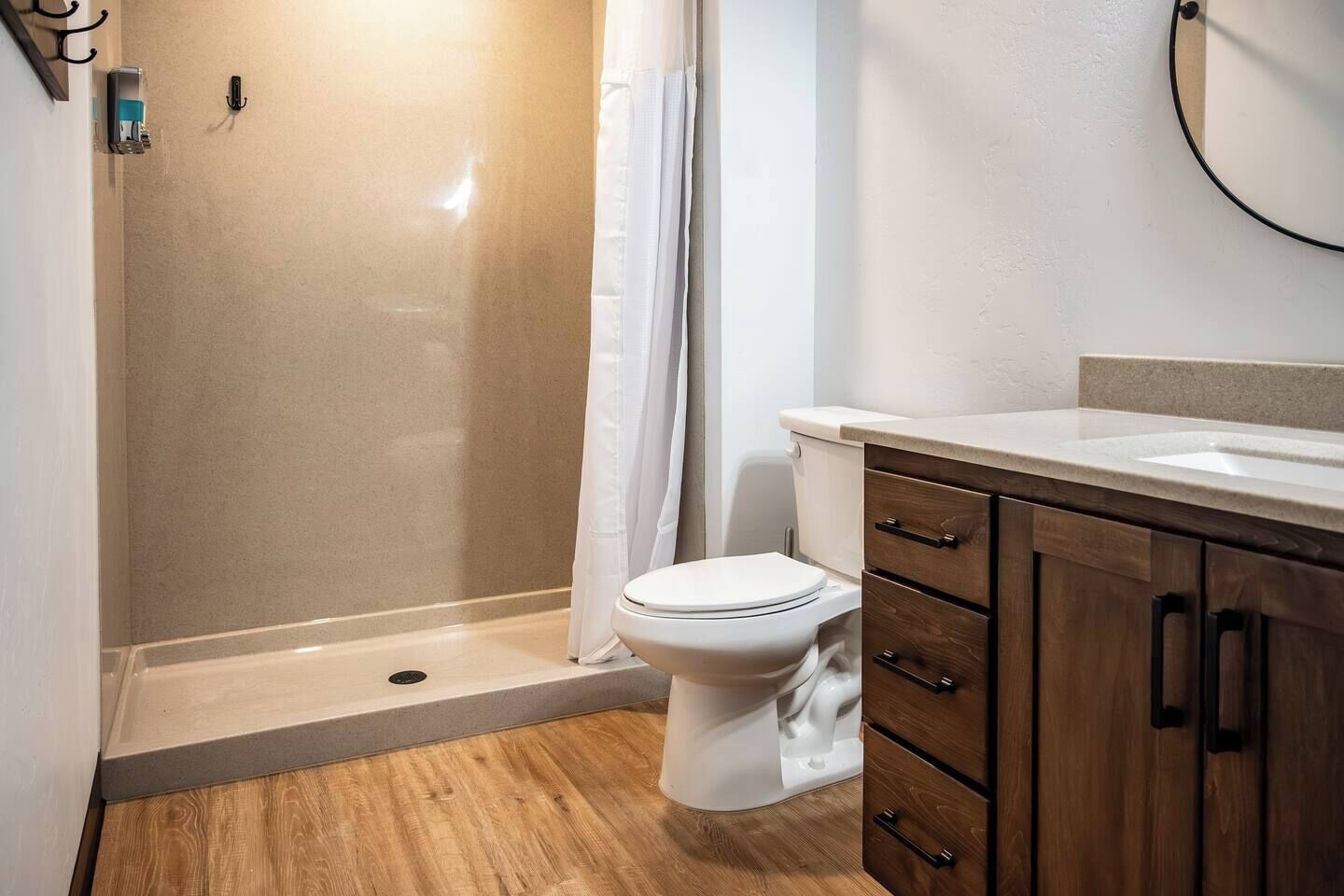 Un bagno con doccia, toilette e mobili in legno.