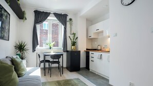 Un espacio habitable compacto con kitchenette, comedor y sofá.