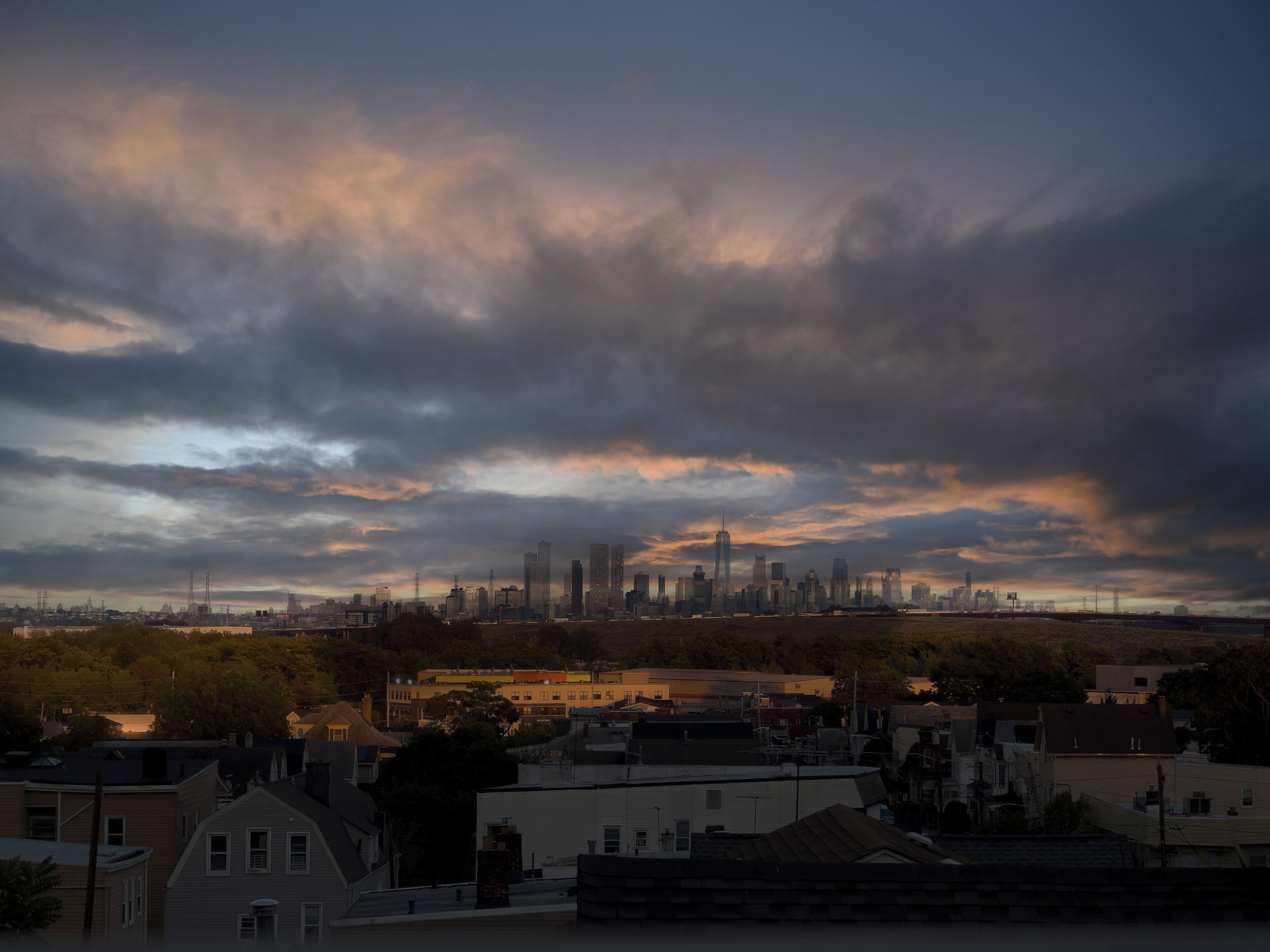 A city skyline with a mix of residential and commercial buildings, including a prominent skyscraper.