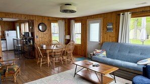 A cozy cabin interior with a dining area, kitchen, and living room.