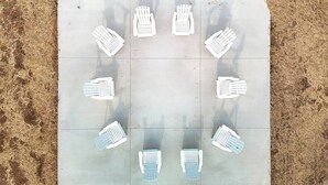 A tiled floor with white and blue chairs arranged in a circular pattern. - Brillion 2‑Bedroom Suite w/ Full Kitchen Near Ariens – Unit #5 (Brillion)