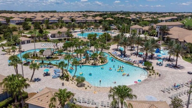 A resort with multiple swimming pools, palm trees, and a large central pool area.