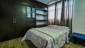 Une chambre à coucher avec un lit, une armoire et un bureau.
