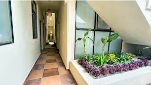 A hallway with a tiled floor, a planter with plants, and a staircase with a glass railing. - Penthouse apartamento con Dos Cuartos en San Juan del Río (San Juan del Río)
