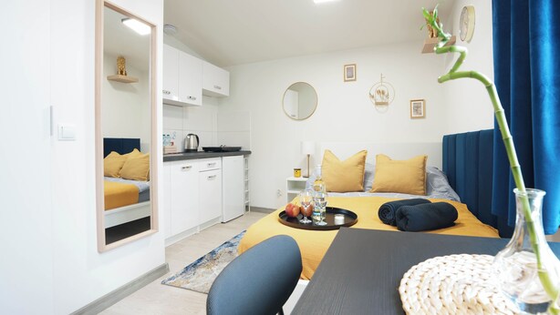Een moderne hotelkamer met een bed, een eethoek en een keuken.