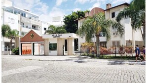 A building with a sign reading "VILLA DAS GAIVOTAS" and a paved courtyard. - Apartment in Ingleses Norte Floriañópolis (Florianópolis)
