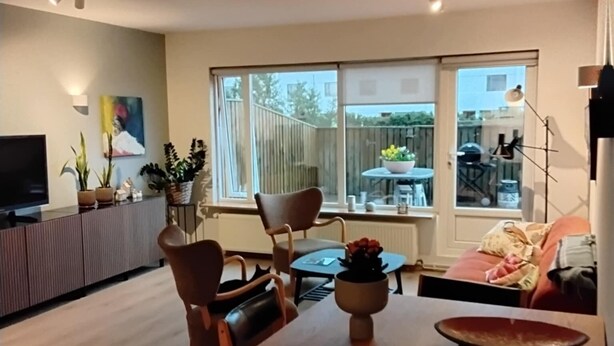 Una sala moderna con comedor, ventanas amplias y vista al jardín trasero.