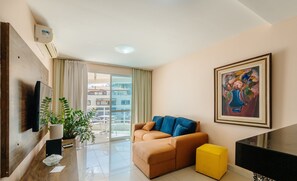 Un salon moderne avec un canapé, un pouf jaune, un piano noir et un tableau accroché au mur.