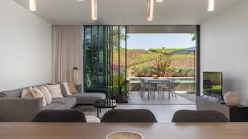A modern living room with a sofa, dining table, and a TV.