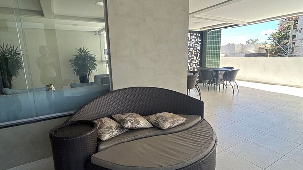 A modern outdoor seating area with a curved sofa and a dining table.