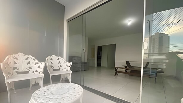 A modern living room with a glass partition, white furniture, and a view of the interior. - Close to the waterfront, 14 people, air conditioning and garage (Petrolina)