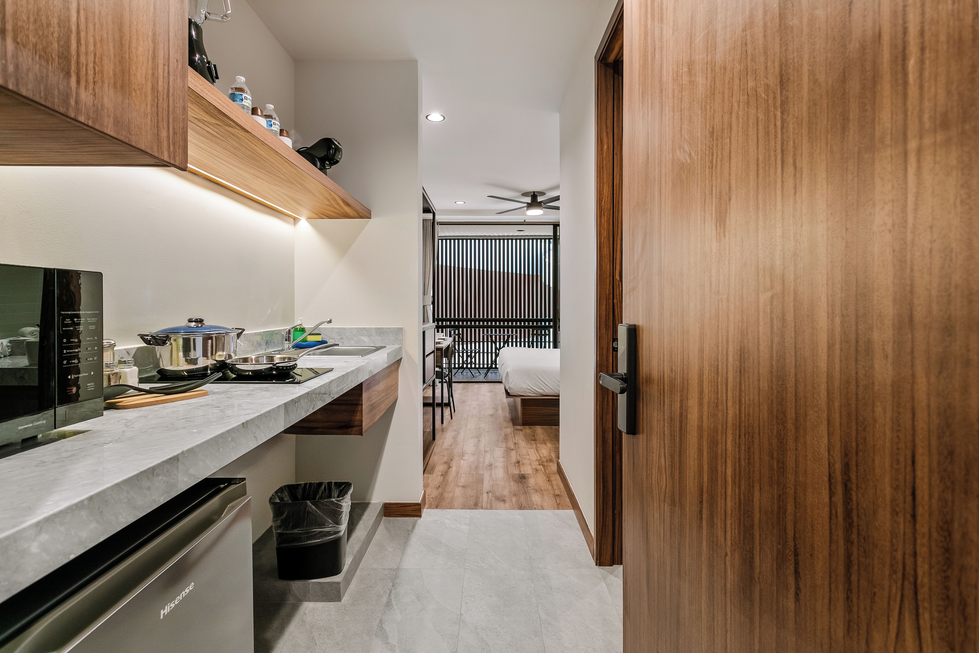 A narrow kitchen with a microwave, stove, and cabinets.