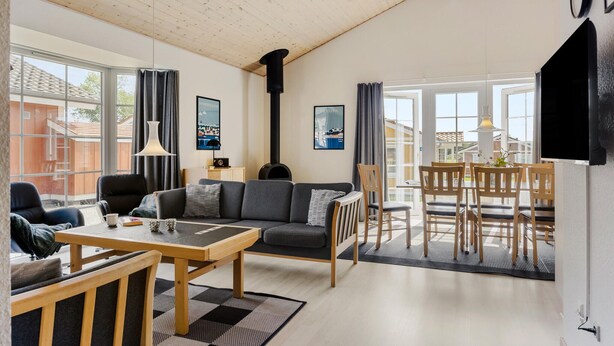 Een moderne woonkamer met een bank, salontafel en een eethoek.