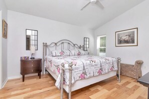 Un dormitorio con cama, mesita de noche y velador.