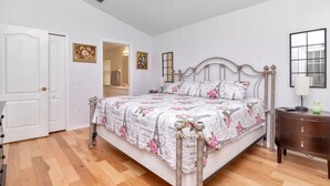A bedroom with a bed, a nightstand, a door, and a ceiling fan. - Deer Run in Wesley Chapel 4br-3ba (Zephyrhills)