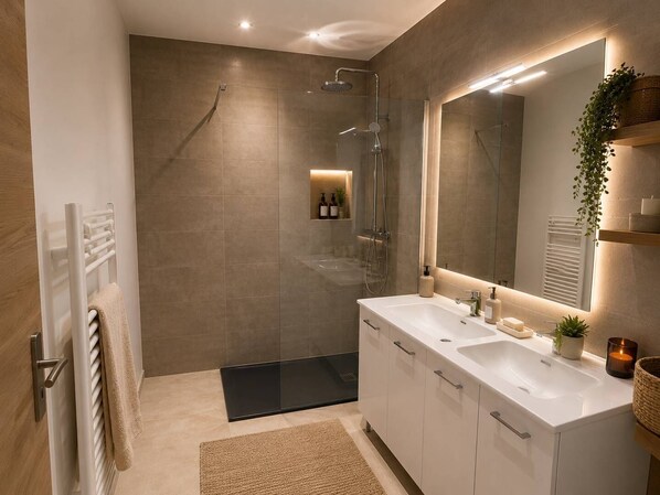 A modern bathroom with a glass shower enclosure, a large mirror, and a double sink vanity.