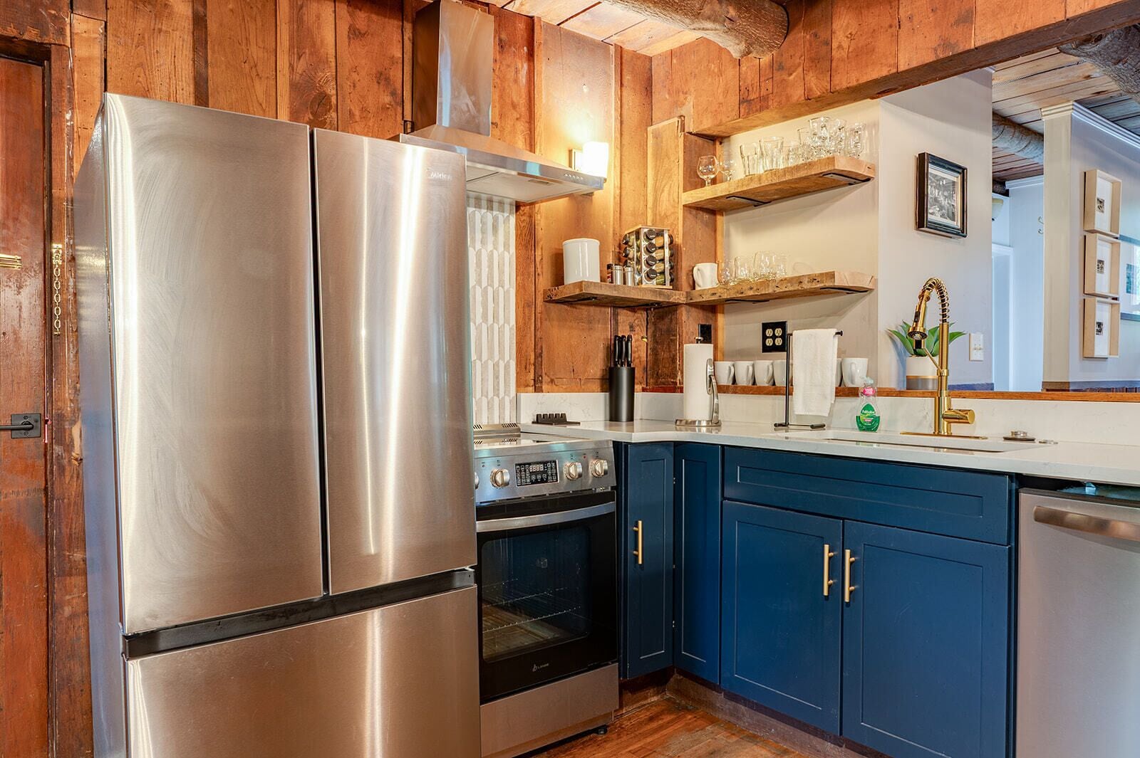 A kitchen with stainless steel appliances, wooden cabinets, and a built-in oven.