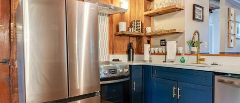 A kitchen with stainless steel appliances, wooden cabinets, and a built-in oven.