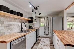 Microones, cafetera i tetera, productes de neteja i una illa a la cuina 