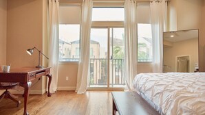 A bedroom with a bed, a desk, a chair, and a large window with curtains. - Pleasant townhome with AC in vibrant Houston (Houston)