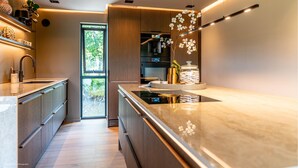 A modern kitchen with a large window, built-in appliances, and a sleek countertop design.