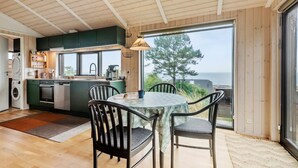 A modern kitchen with a large window, a dining area with two chairs, and a view of the sea. - 1 bedroom stunning home in Esbjerg V (Esbjerg V)