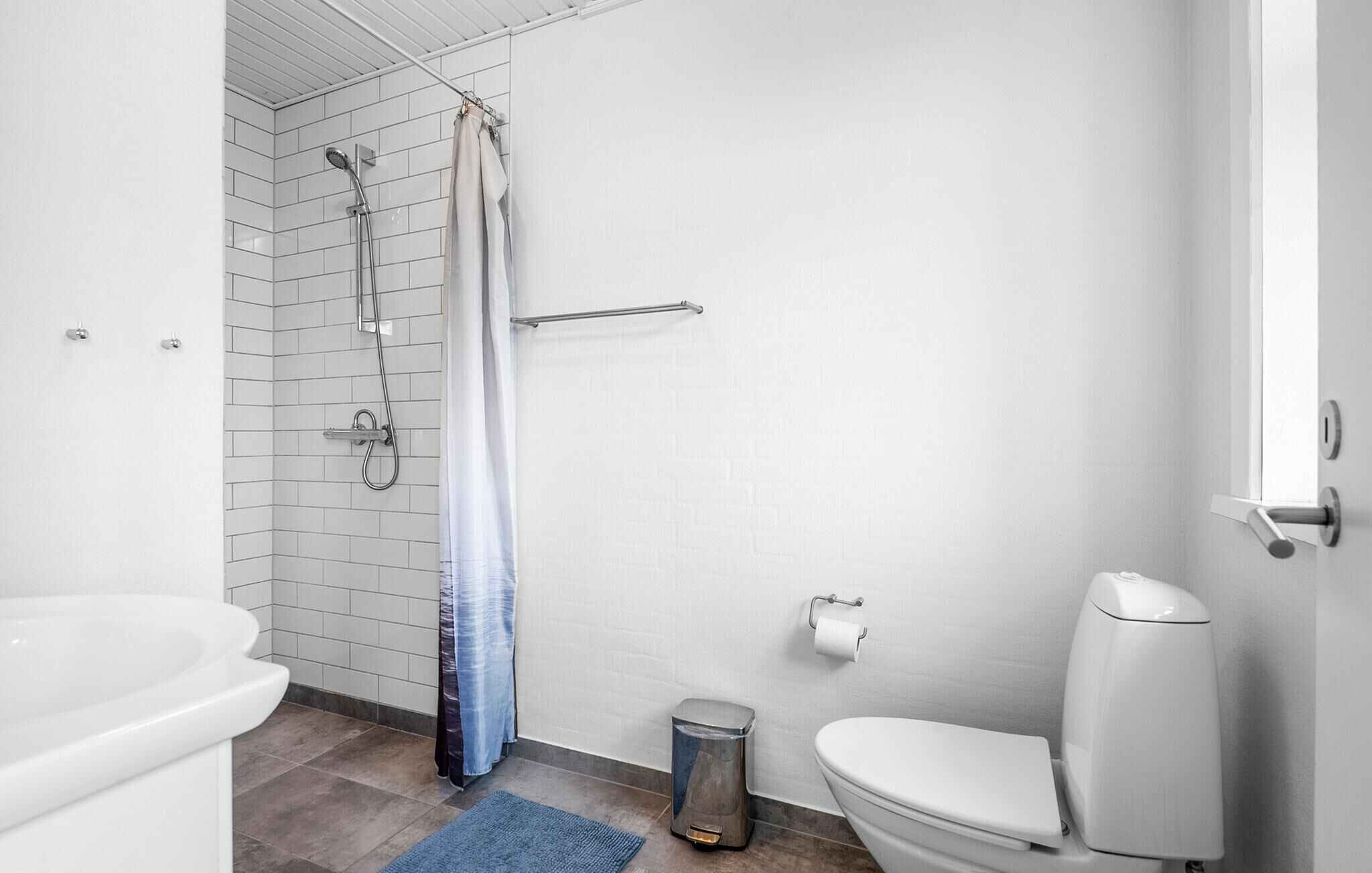 A bathroom with a shower, toilet, and sink.