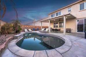 A backyard with a swimming pool, lounge chairs, a barbecue area, and a covered patio. - Stylish & Cozy Home in Coachella (Coachella)