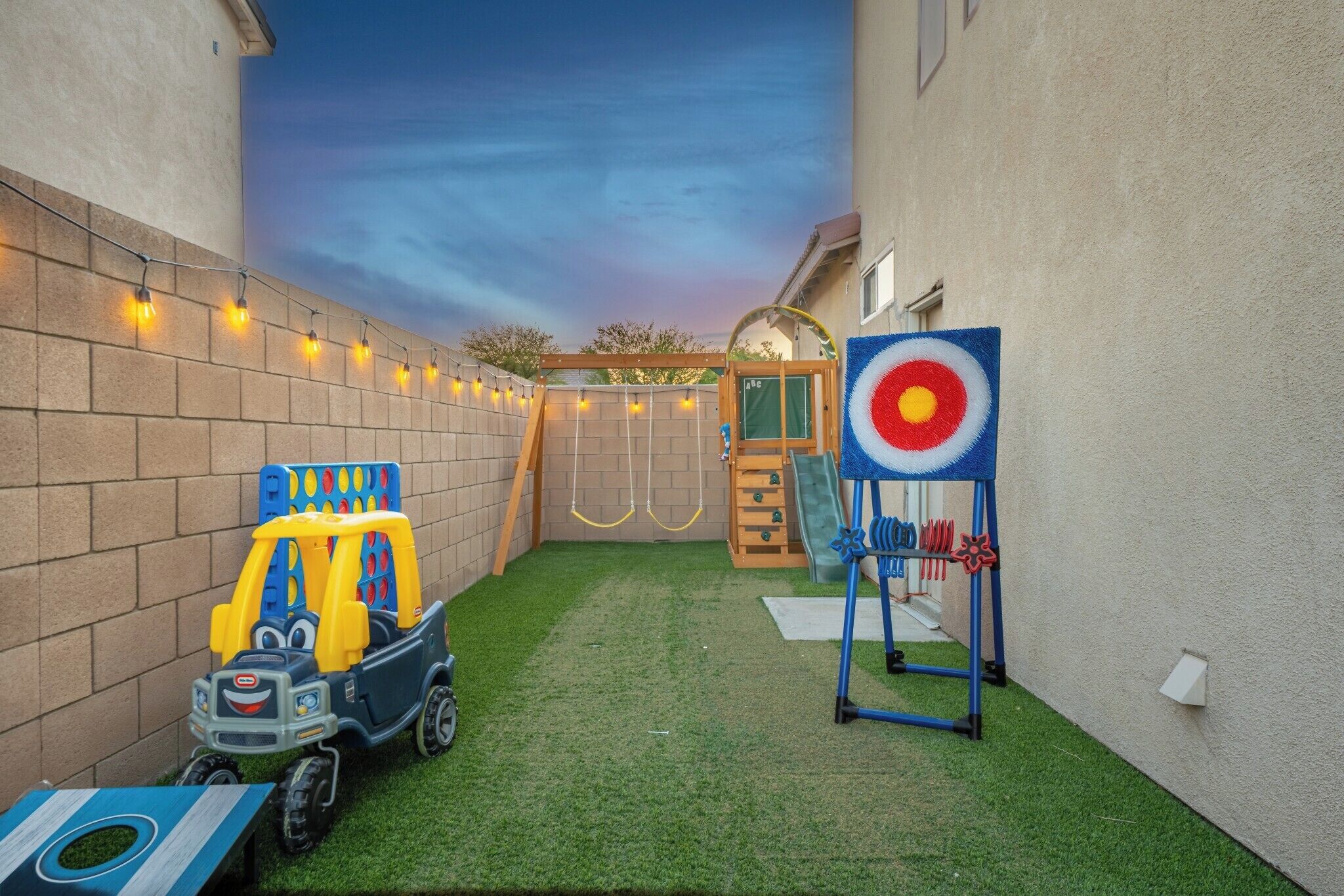 A children's play area with a toy car, a target, and a swing set.
