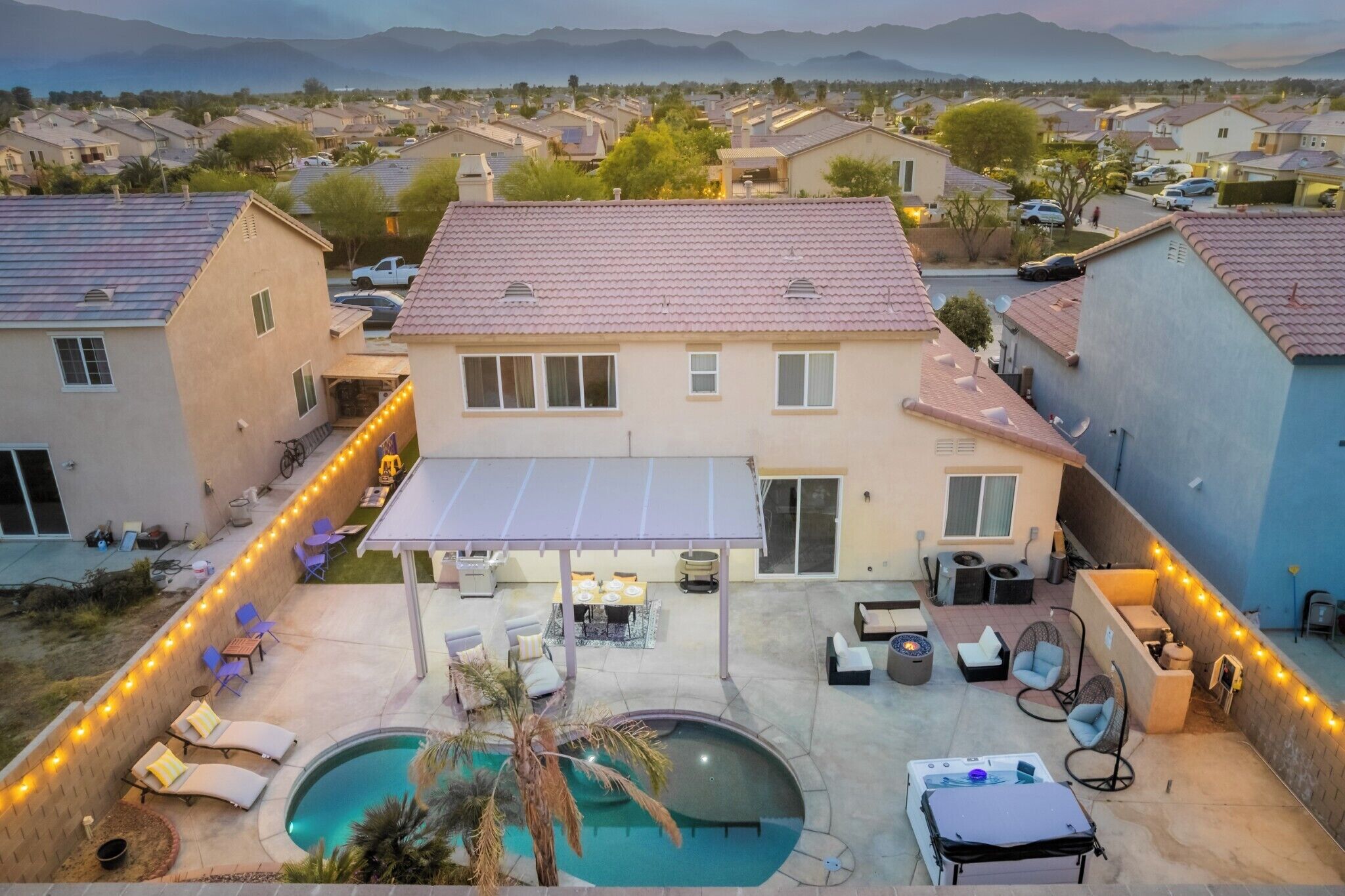 A residential property with a backyard patio, a swimming pool, and a covered outdoor seating area.