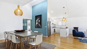 A modern kitchen with white cabinets, a built-in oven, and a black stove.