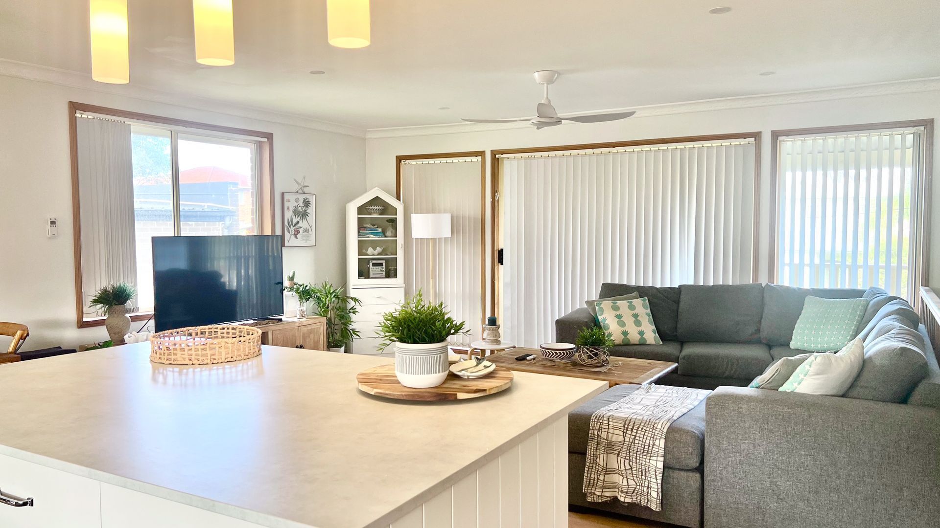 A modern living room with a sofa, a coffee table, and a television.