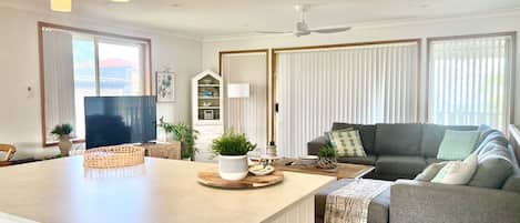 A modern living room with a sofa, a coffee table, and a television.