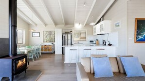 Une cuisine moderne avec des armoires blanches, un réfrigérateur en acier inoxydable et un coin bar.