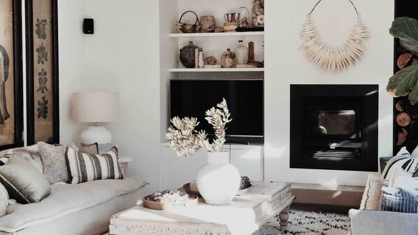 A modern living room with a sofa, a coffee table, and a fireplace. - The Tasman Secret, moments to Manyana Beach (Manyana)