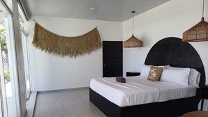 Une chambre moderne avec un cadre de lit noir, du linge de lit blanc et une décoration murale tissée.